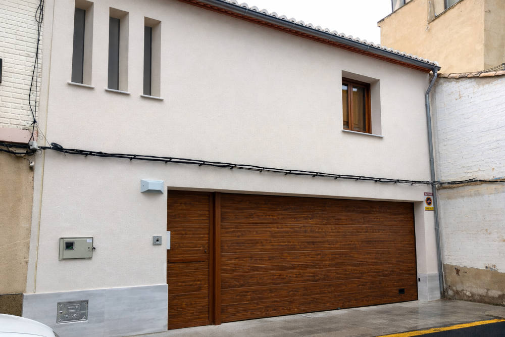 Puerta de garaje seccional acabado madera con puerta peatonal en Vilagarcía de Arousa Puerta de garaje seccional imitación madera con puerta peatonal instalada en Vilagarcía de Arousa