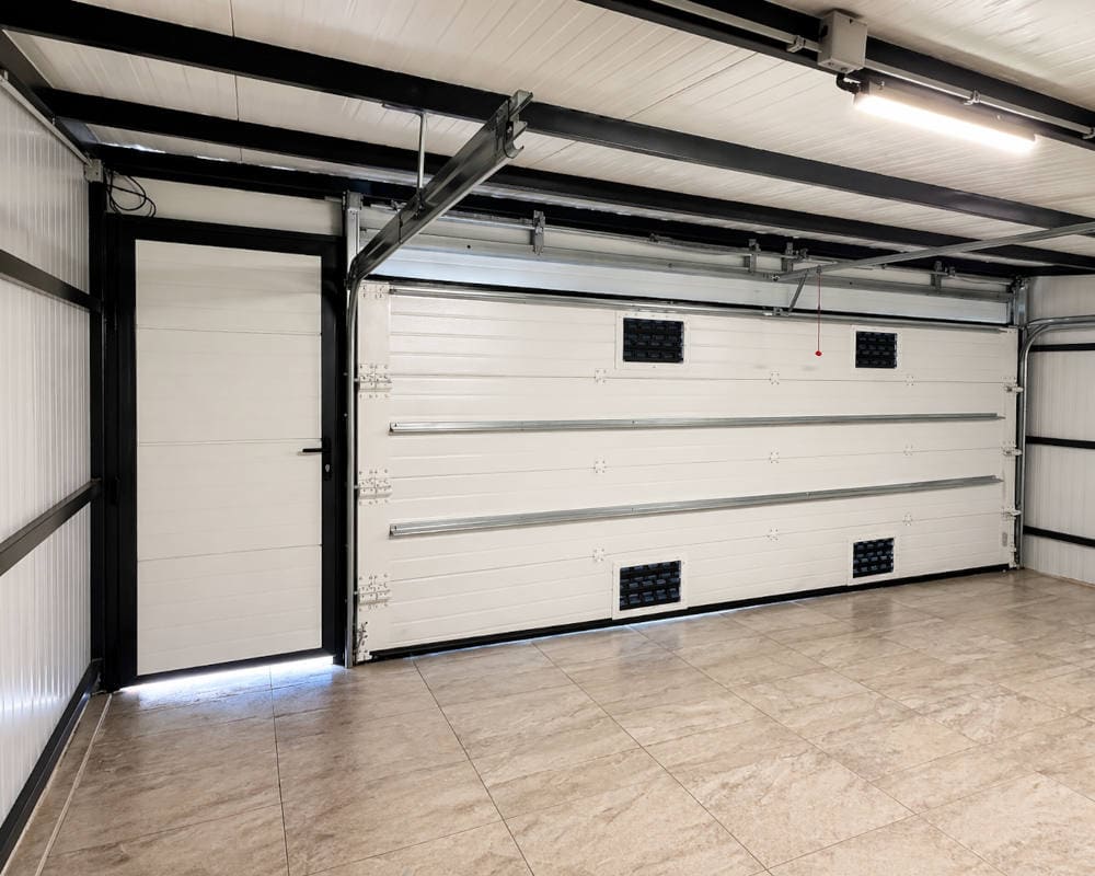 Puerta de garaje seccional blanca con puerta peatonal instalada en Poio