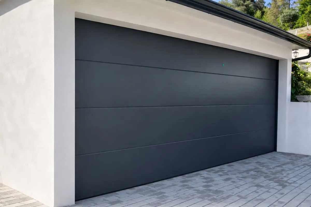 Puerta de garaje seccional gris antracita RAL 7016 instalada en vivienda moderna