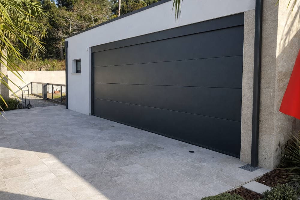 Puerta de garaje seccional gris antracita instalada en vivienda moderna en Marín Pontevedra