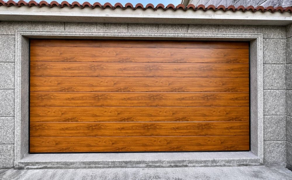 puerta de garaje Seccional madera clara en vivienda tradicional en Sanxenxo